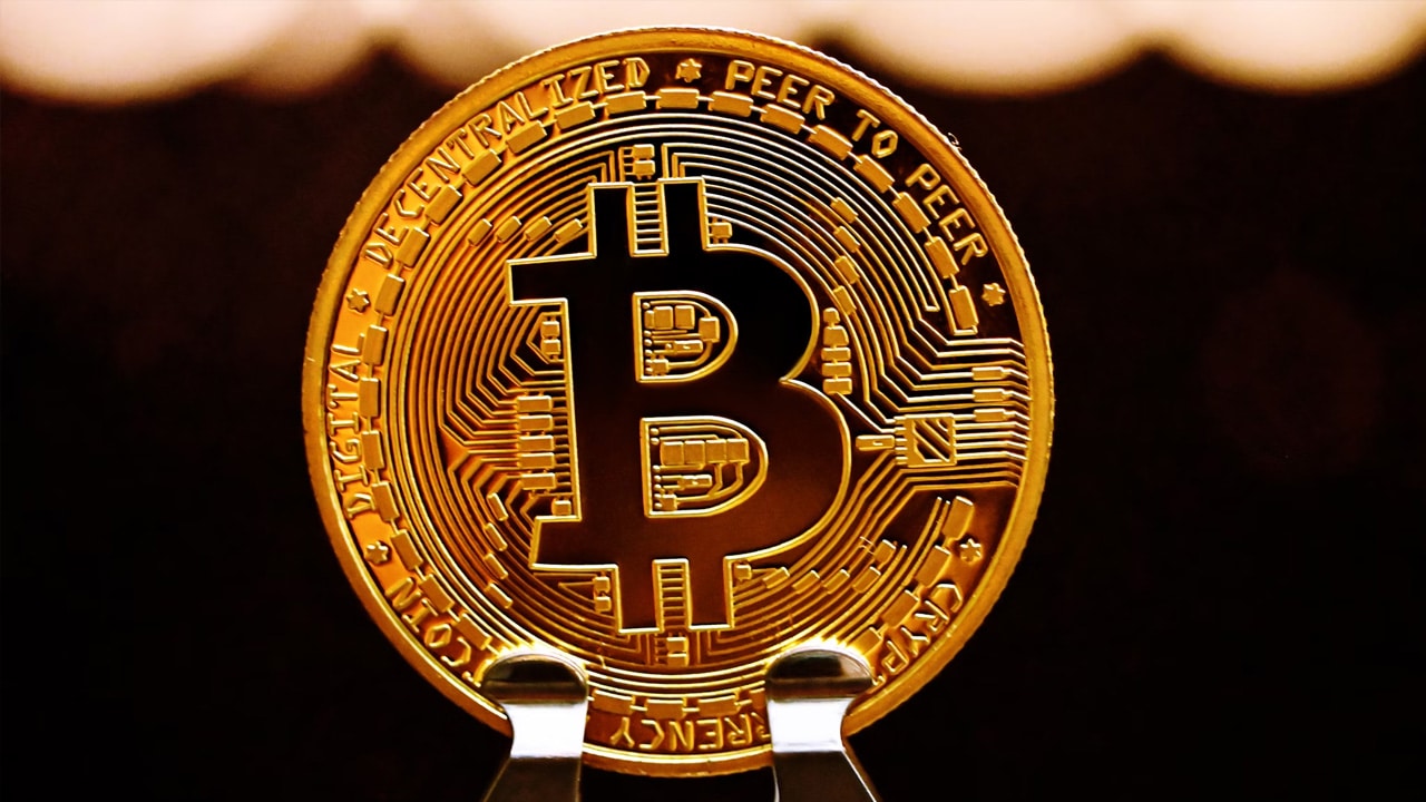 uma moeda Bitcoin em cima de um suporte